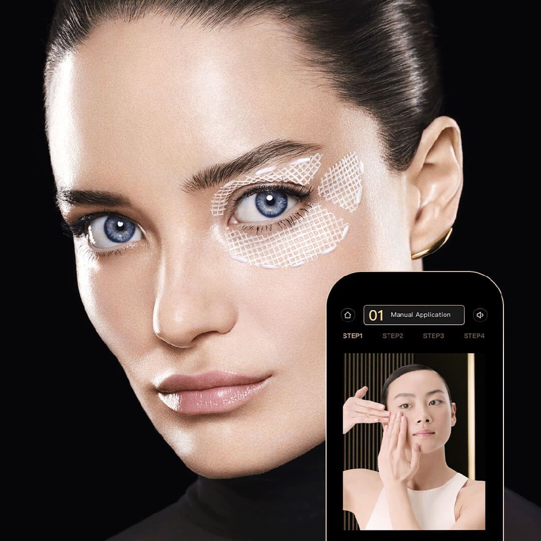 Close-up of a woman's face with eye patches. A phone displays a tutorial.