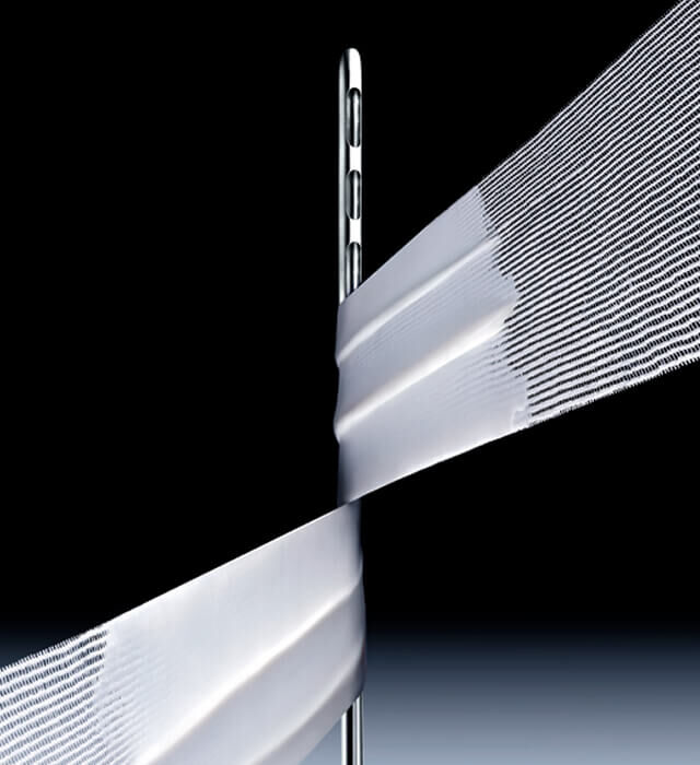 A silver medical needle, surrounded by white and transparent mesh bands that wrap around it, against a dark background.