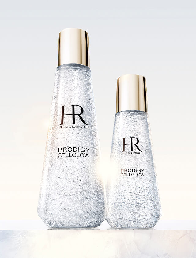 Two transparent Helena Rubinstein Prodigy Cellglow serum bottles, one large and one small, filled with hydrating bubbles and golden caps, set against a light background.
