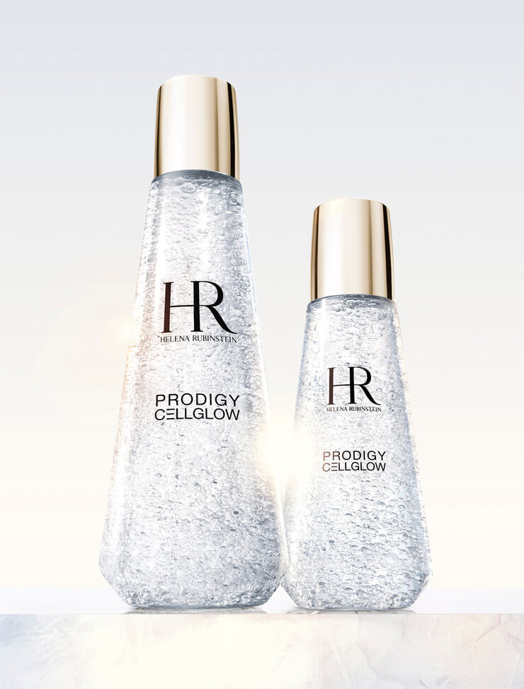 Two transparent Helena Rubinstein Prodigy Cellglow serum bottles, one large and one small, filled with hydrating bubbles and golden caps, set against a light background.