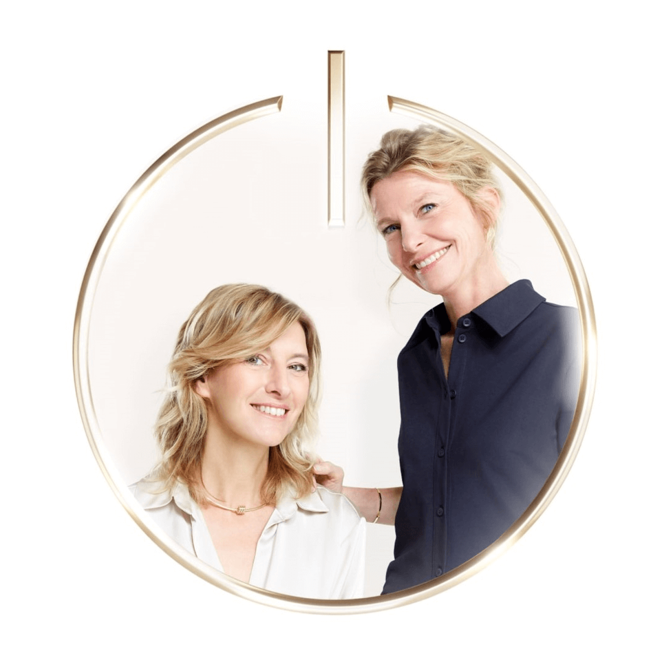 Two smiling women, one blonde and one with darker hair, are depicted within a golden circle with a "power" symbol at the top, on a white background.