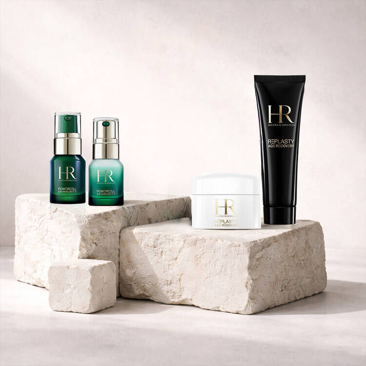 Four Helena Rubinstein skincare travel-size products on stone blocks​