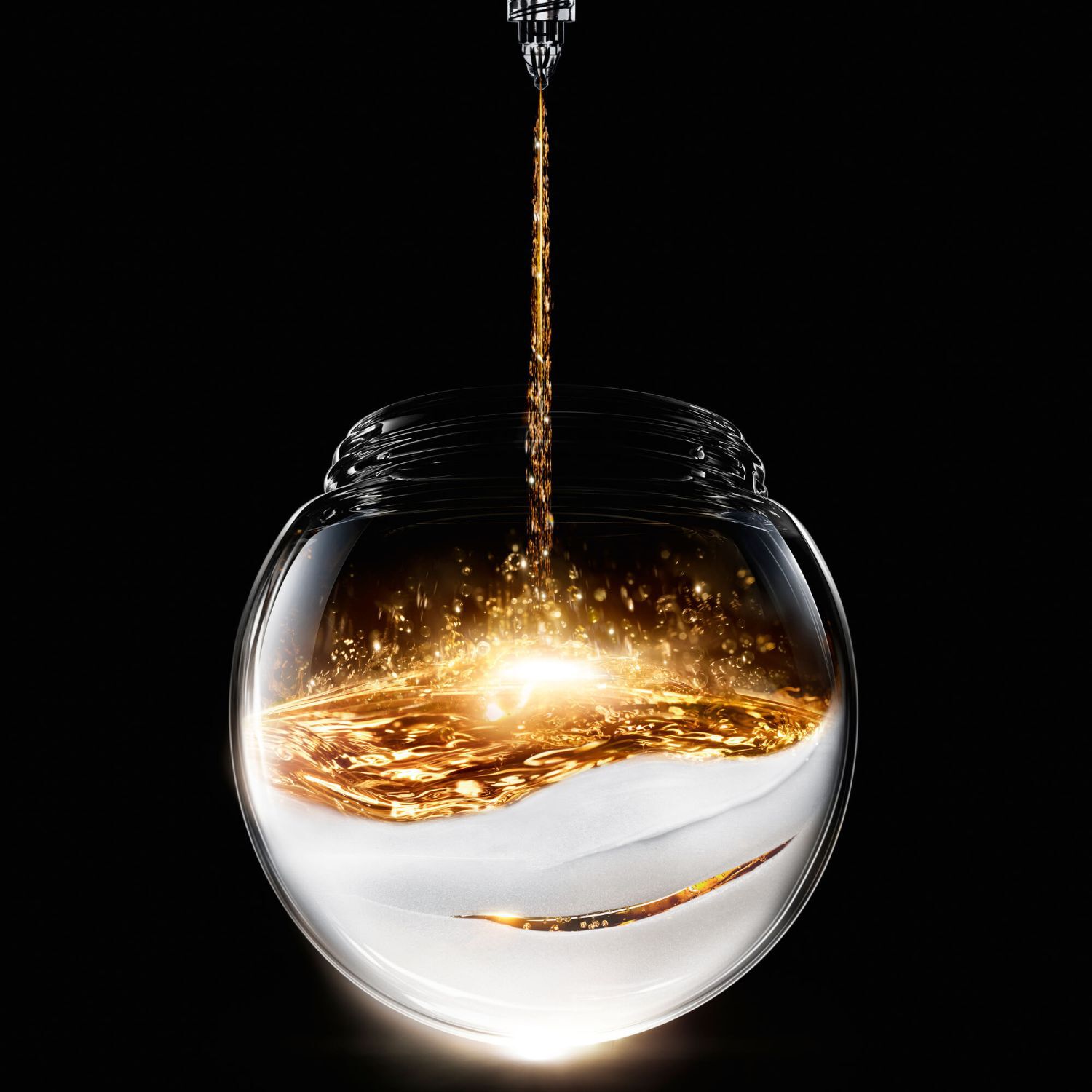 Sparkling golden liquid pours into a spherical glass jar, resting on a textured white base, creating a luminous contrast on a black background.