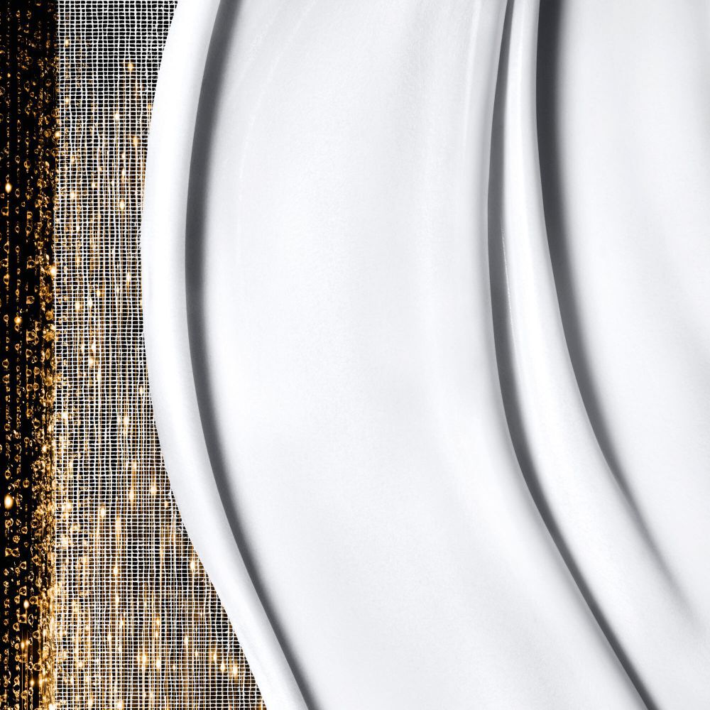 Smooth, creamy white texture with gentle waves on the right, juxtaposed with shimmering, abstract golden patterns on the left.